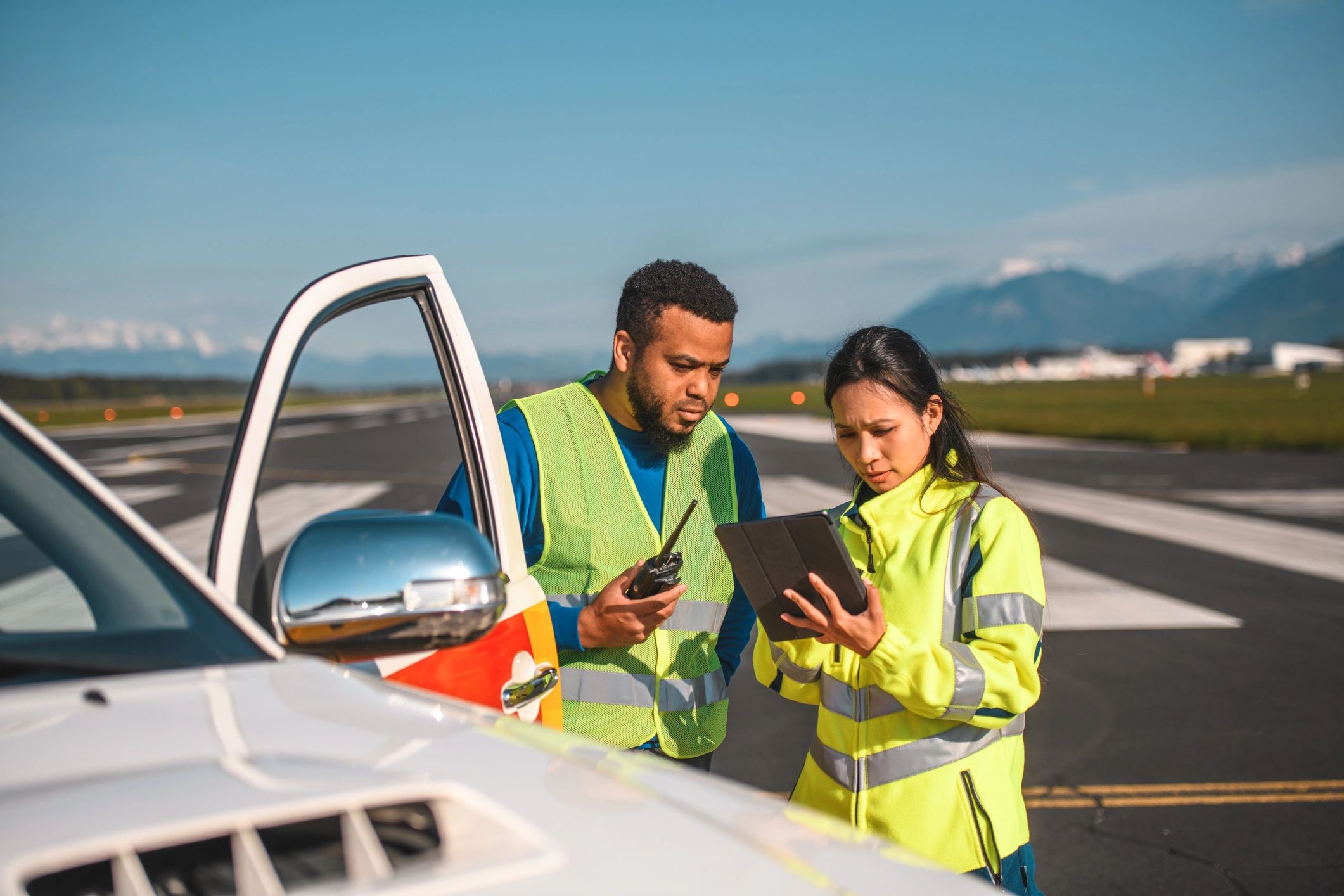 Instructor and student reviewing a flight plan on a tablet at an airfield
