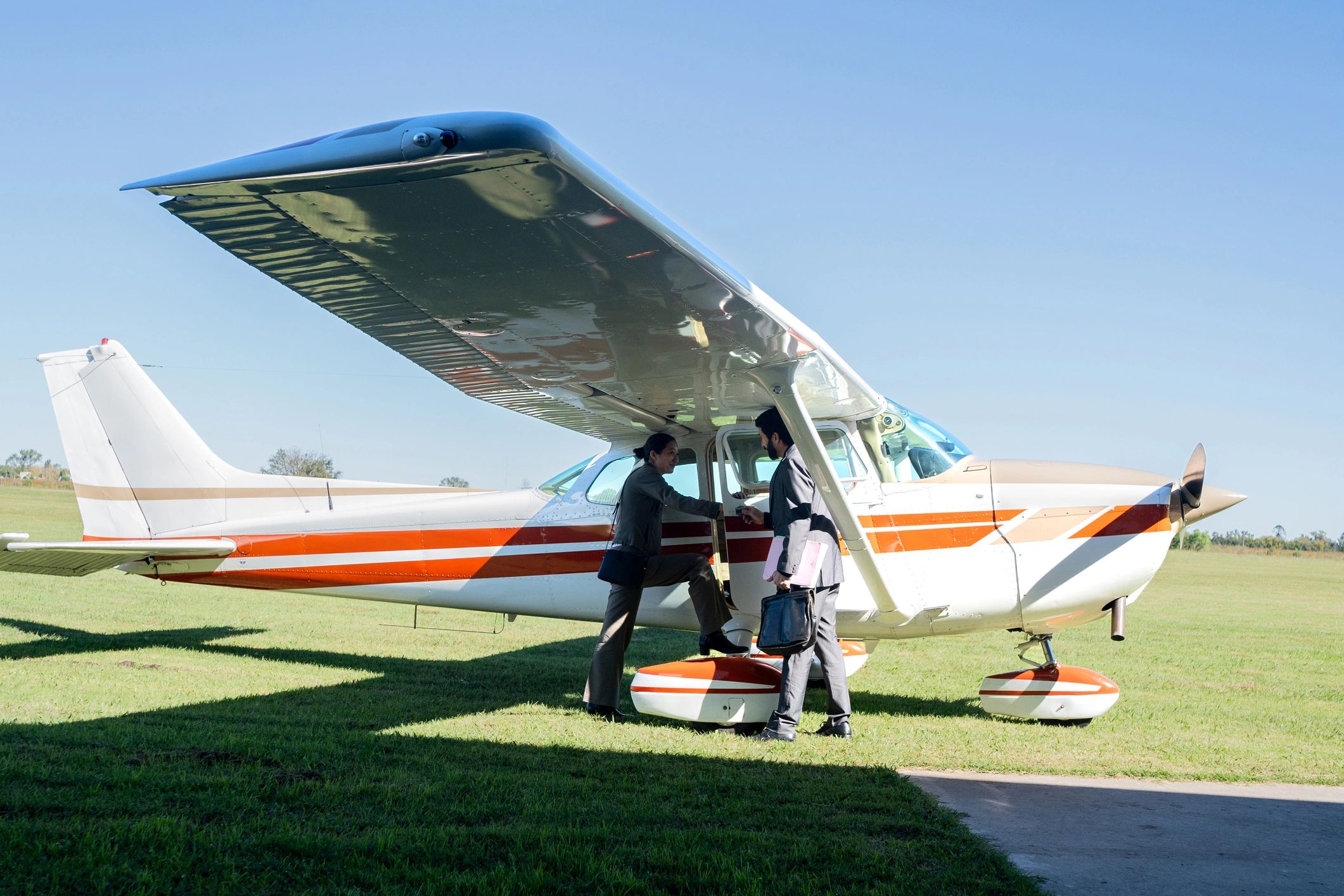 Two people walking toward a small aircraft