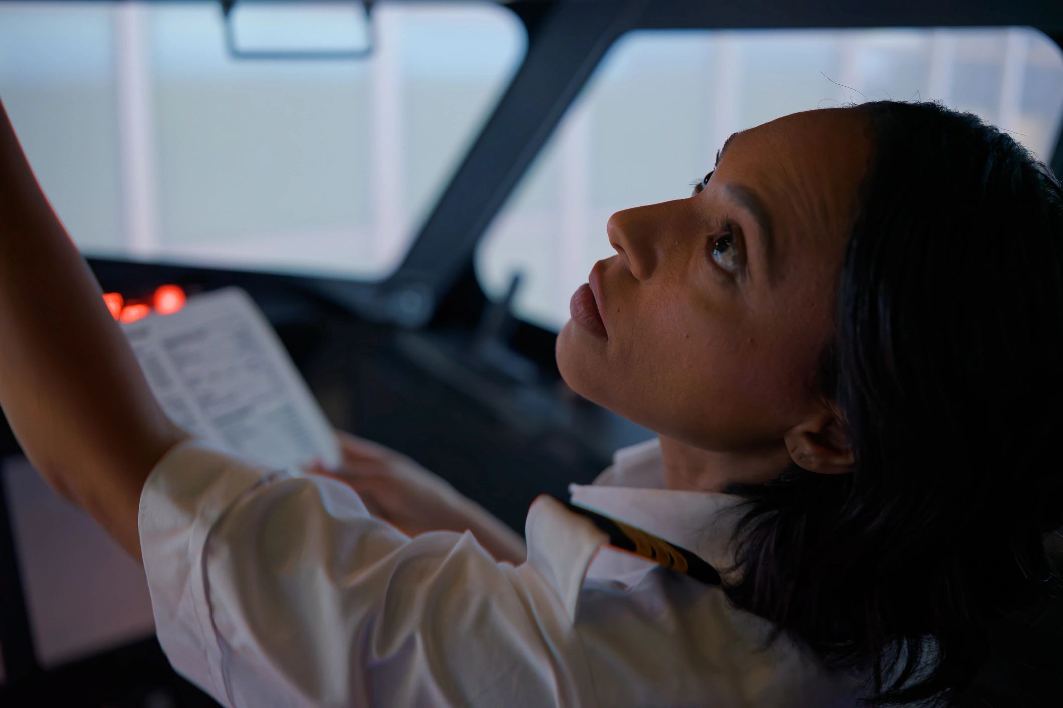 Pilot holding a checklist in a cockpit