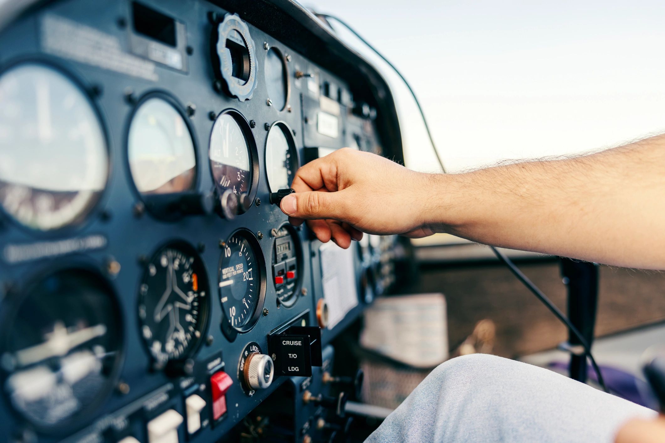 Pilot adjusting controls on an airplane cockpit instrument panel